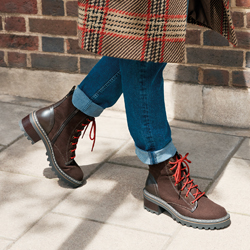 Woman wearing hiking boots with jeans and a plaid coat