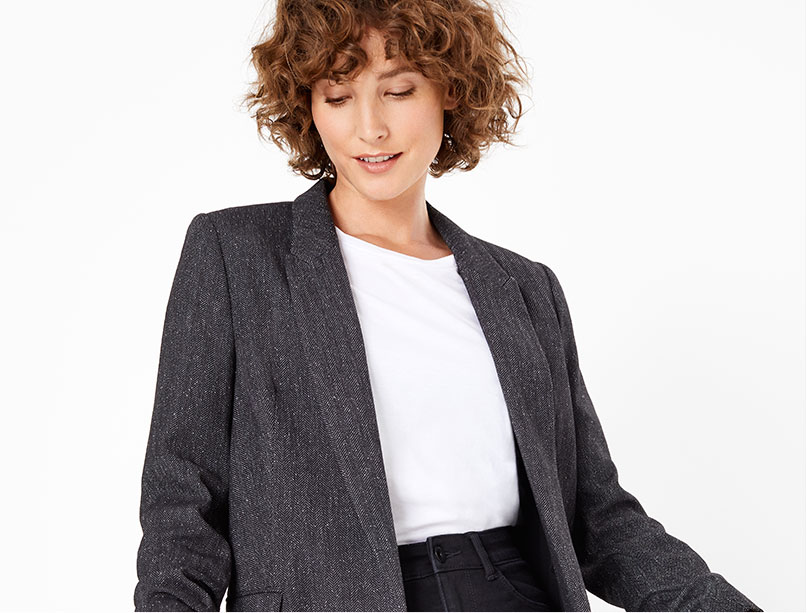 Femme portant un blazer gris et un t-shirt blanc